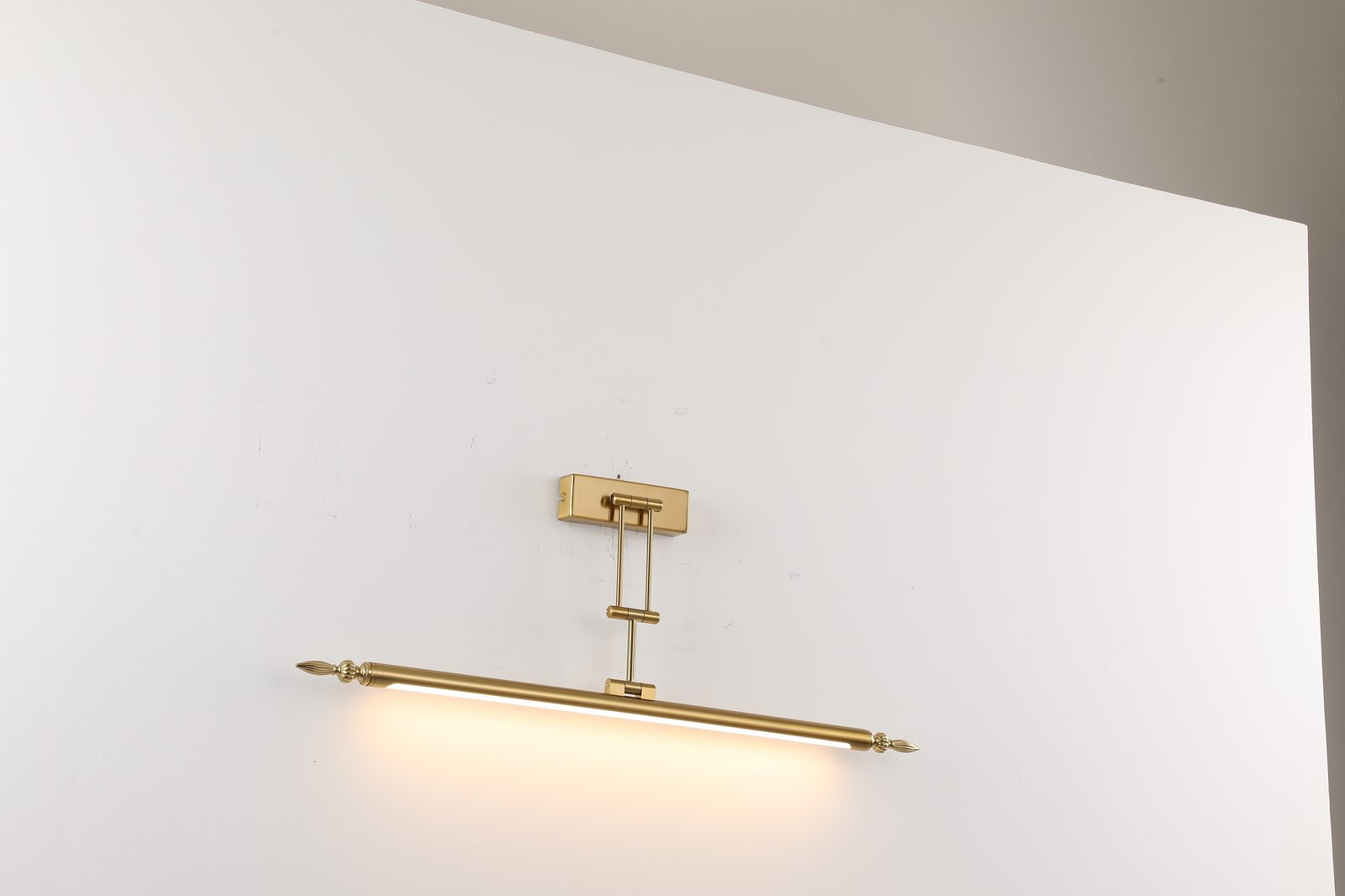 Wandleuchte in Messing-Optik mit warmweißem Licht an weißer Wand