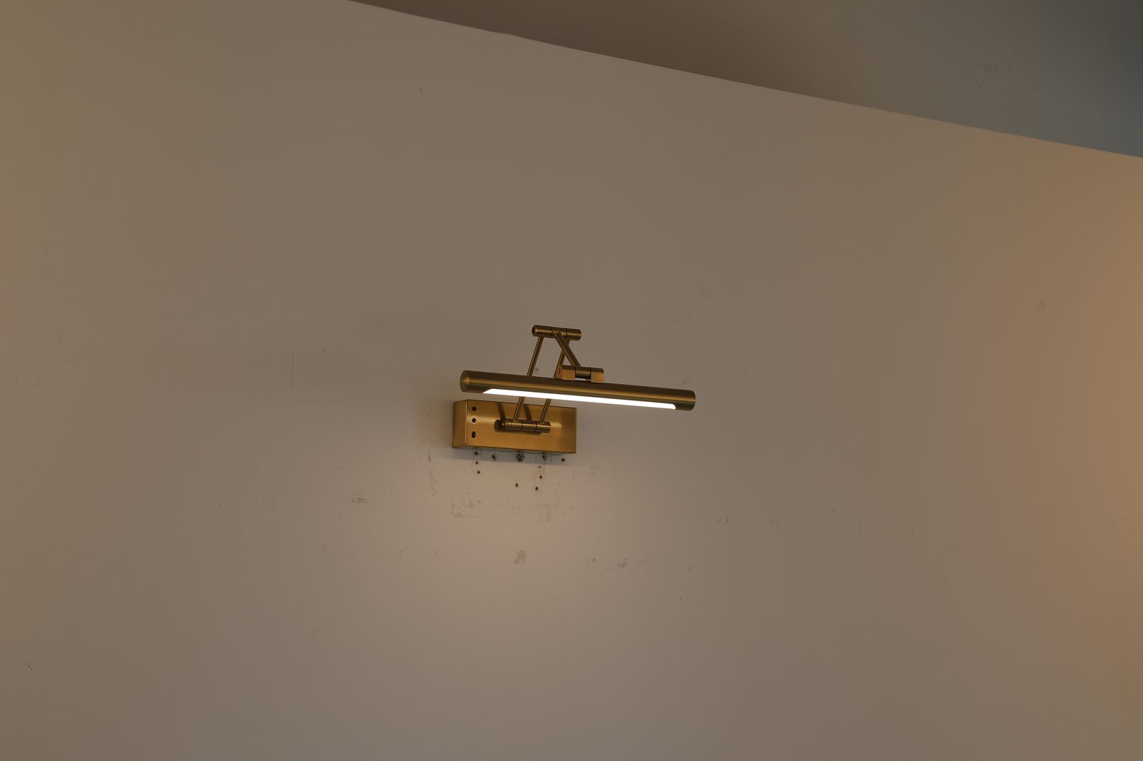 Leuchte in Messing-Optik, Edelstahl 304, an weißer Wand
